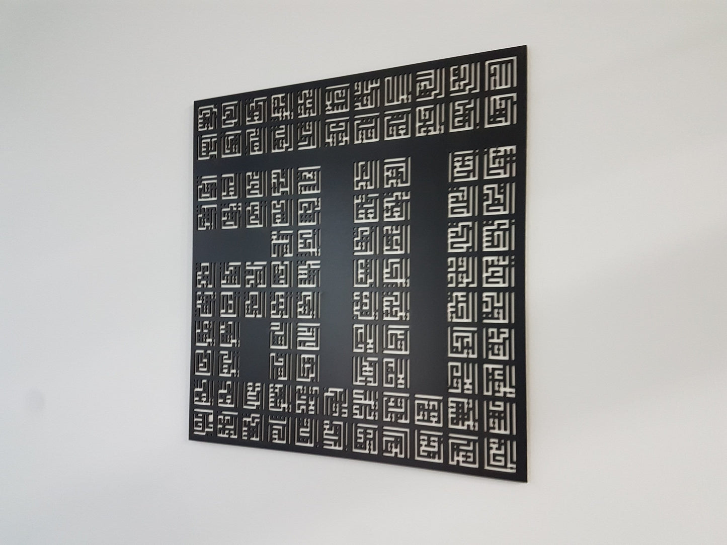 Angled view of the 99 Names of Allah wooden panel showing its depth on the wall
