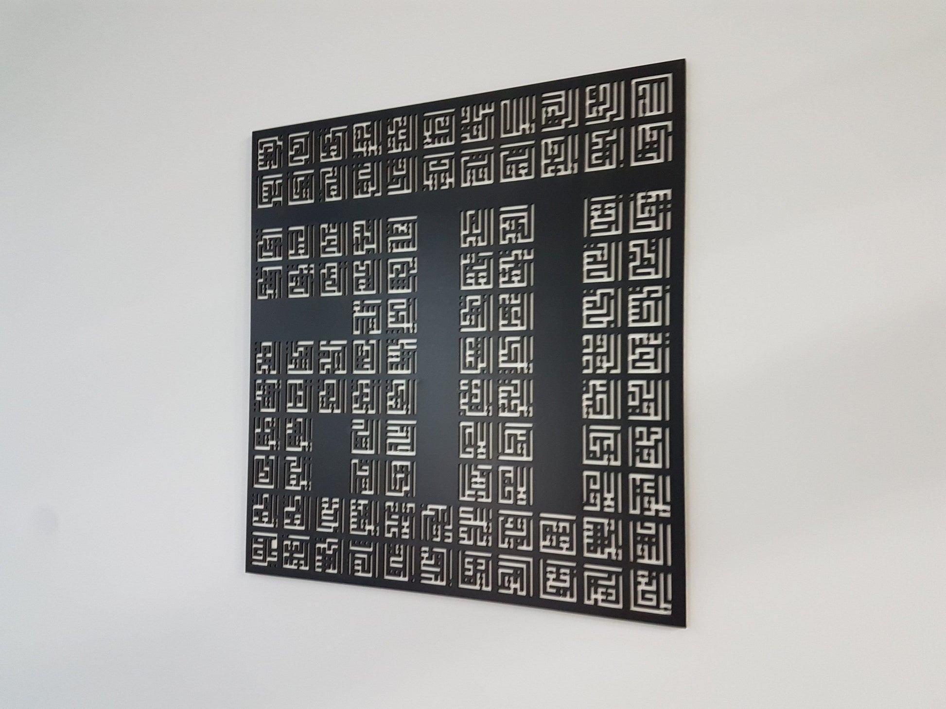 Angled view of the 99 Names of Allah wooden panel showing its depth on the wall