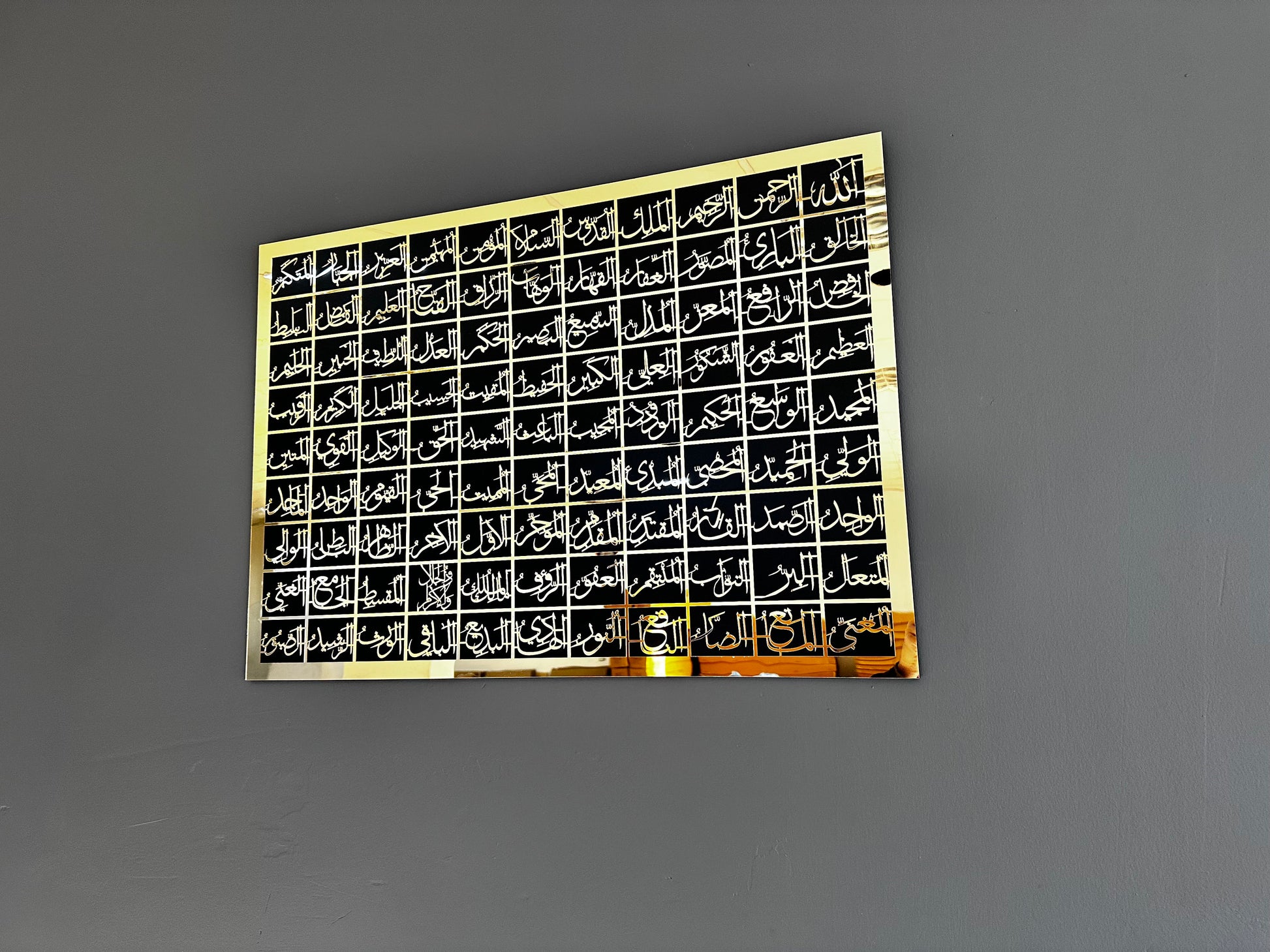 Asmaul Husna gold on black wall decor in interior setting