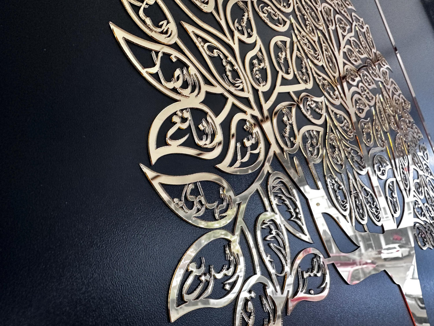 Close-up of the mirrored acrylic Arabic calligraphy forming the leaves of the tree